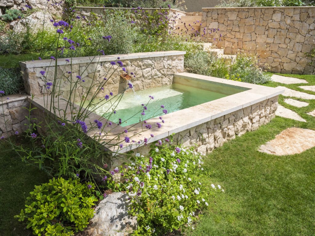 Lavoir revisité en bassin, en pierre pour rappeler les matériaux de la villa