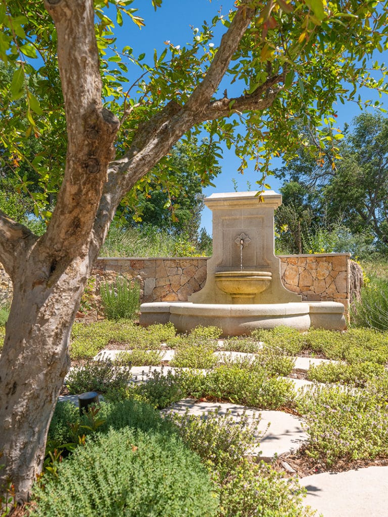 Landscaped garden, aromatic herbs, and stone fountain