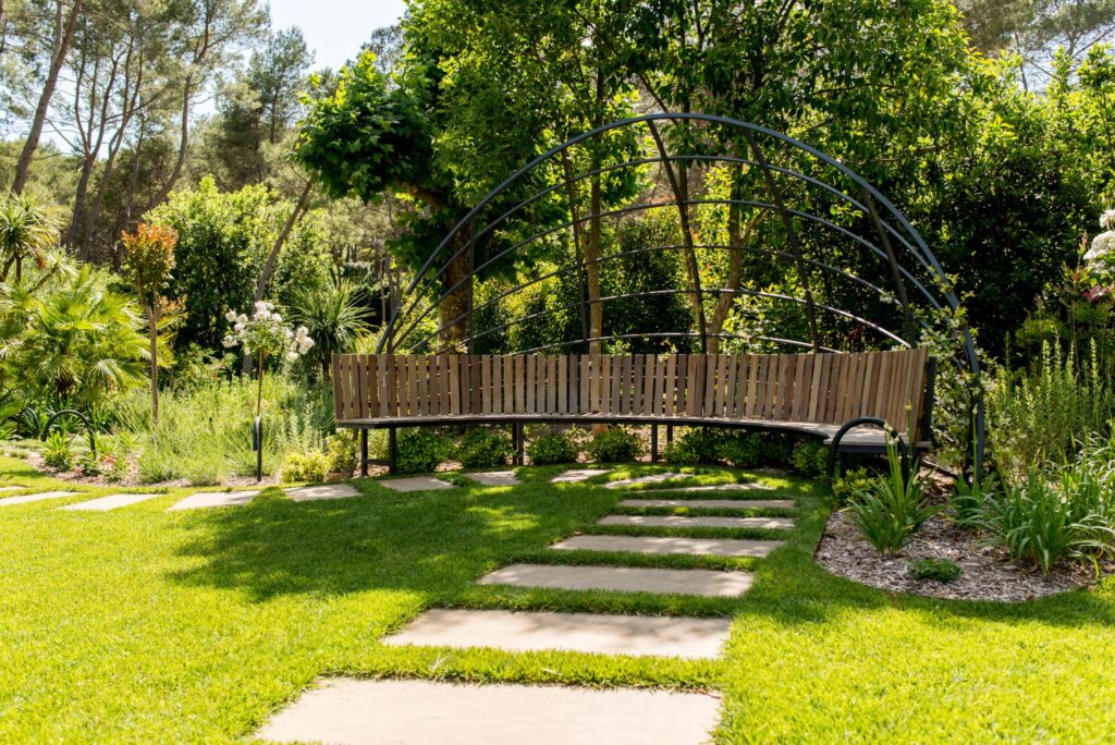 Banc courbe sous une pergola métallique au cœur d’un jardin naturel à Mougins