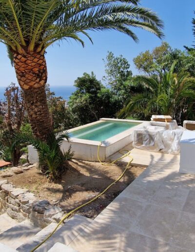Terrasse en cours de rénovation avec palmier, petit bassin et vue sur la mer
