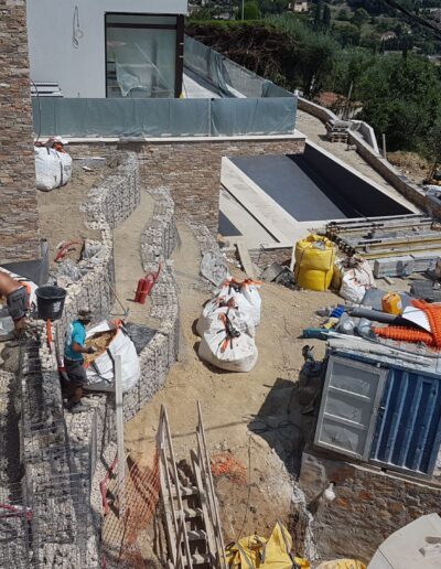 Installation de murets en gabions et travaux de construction autour de la piscine.