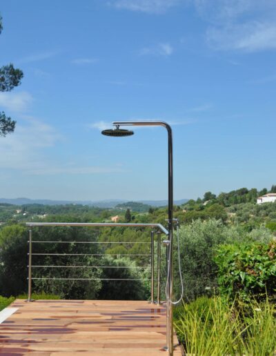 Douche extérieure en inox sur terrasse bois avec vue panoramique sur les collines