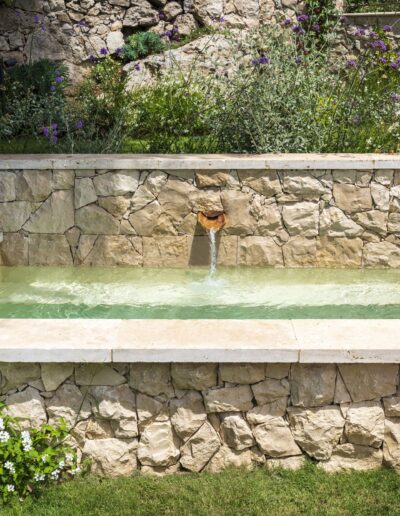 Fontaine alimentant le bassin en pierre dans le jardin de la villa Hinn