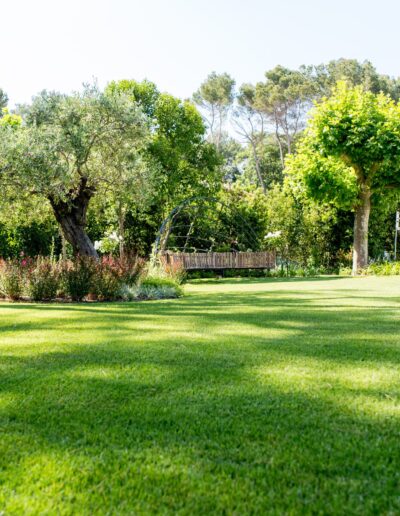 Grande pelouse entourée d’arbres et de massifs fleuris dans un jardin à Mougins