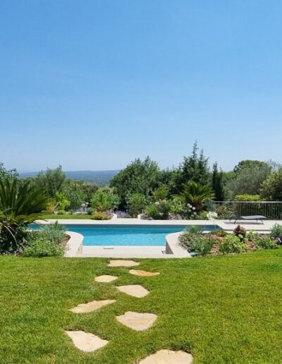 Completed landscaping with pool, Mediterranean plants and renovated white retaining walls