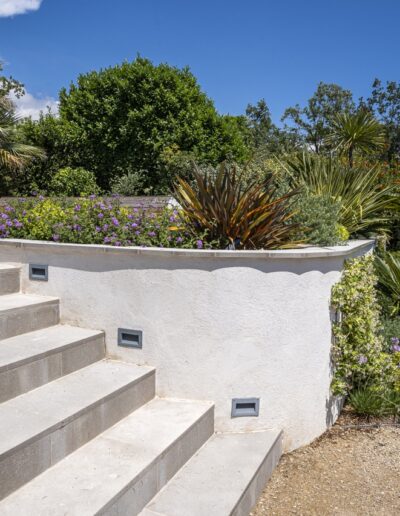 Outdoor stone staircase surrounded by flower beds and Mediterranean plants