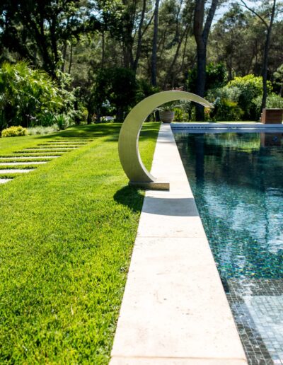 Pool edge with stainless steel water feature in a landscaped garden in Mougins