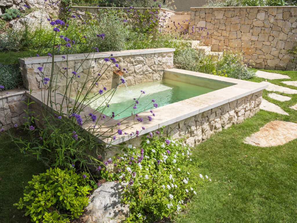 Traditional washbasin reimagined as a stone water basin, echoing the villa’s materials