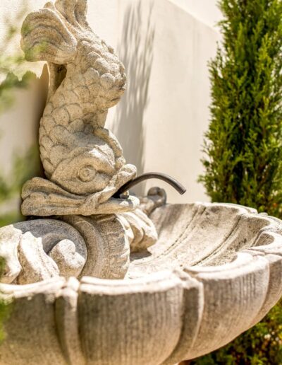 Stone fish-shaped fountain in an elegant garden