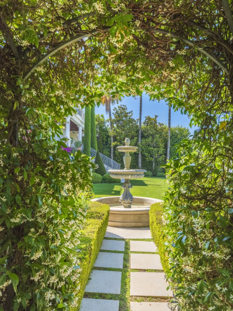 Stone fountain in a garden designed by Adonis Paysages