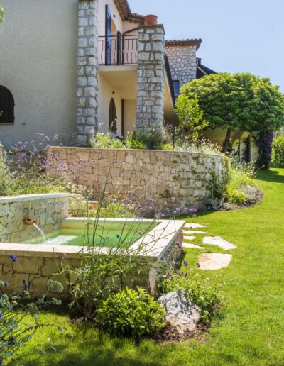 Semi-sunken stone pool in the garden of Villa Hinn, surrounded by Mediterranean plants