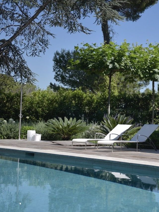 Sun loungers on a wooden terrace in front of a pool