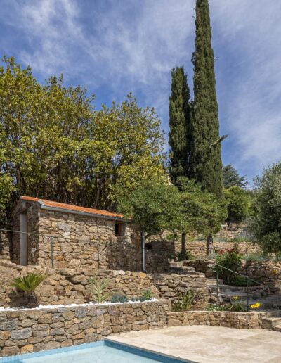 Stone hut and garden steps integrated into a terraced landscape with lush vegetation