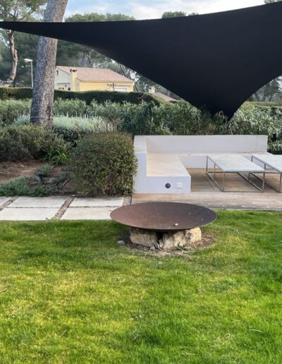 Espace terrasse avant aménagement, avec banquette et voile d’ombrage avant la mise en valeur du jardin