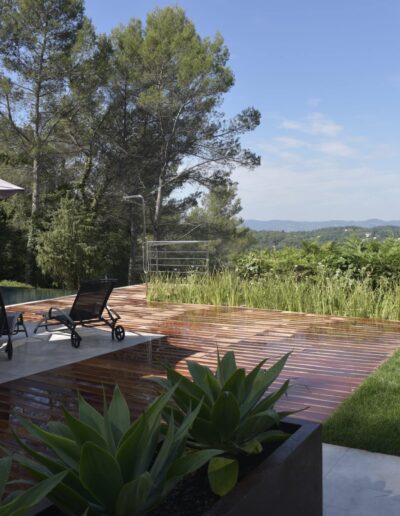 Terrasse bois avec chaises longues et vue dégagée sur la vallée